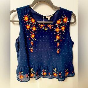Blue printed sleeveless top. Cuts at the waist.